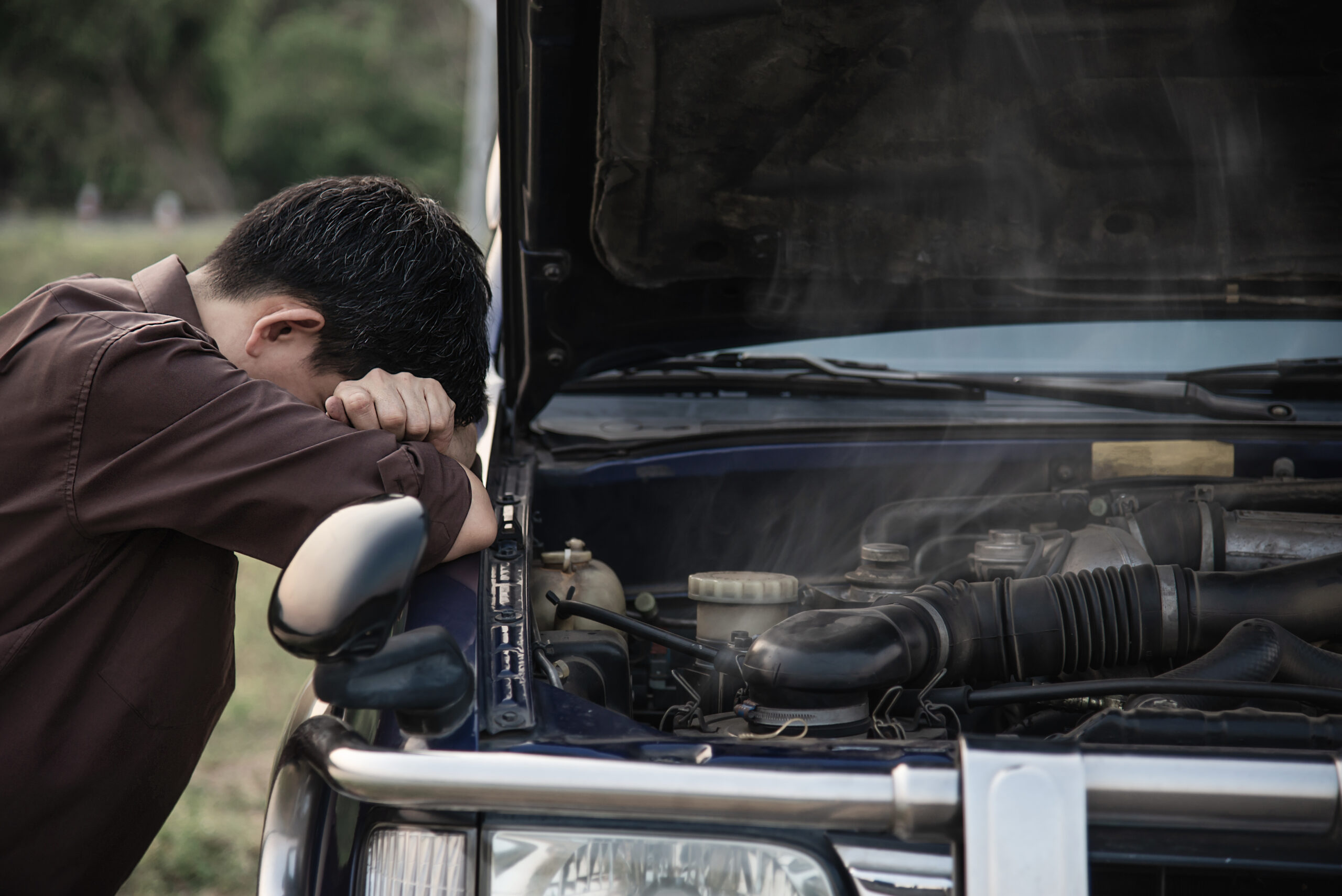 Man try to fix a car engine problem on a local road Chiang mai Thailand - people with car problem transportation concept